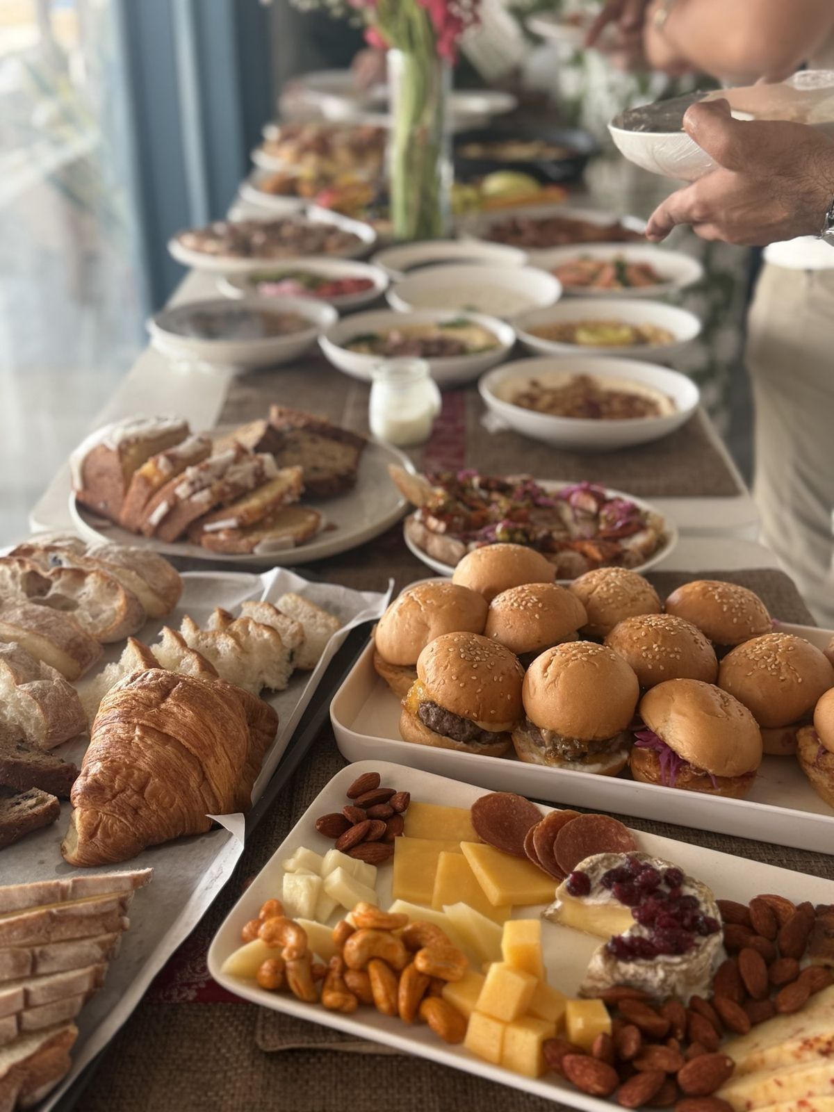 Brunch spread with sliders, fresh breads, croissants and a cheese board