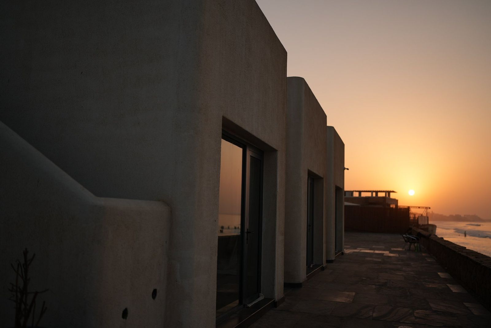 Room blocks along the seafront terrace at sunset